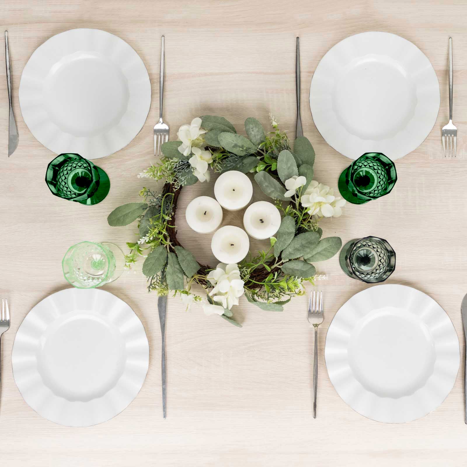 Assorted green crystal cut reusable plastic cocktail goblets on a dining table.