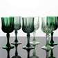 Assorted green crystal cut reusable plastic cocktail goblets.
