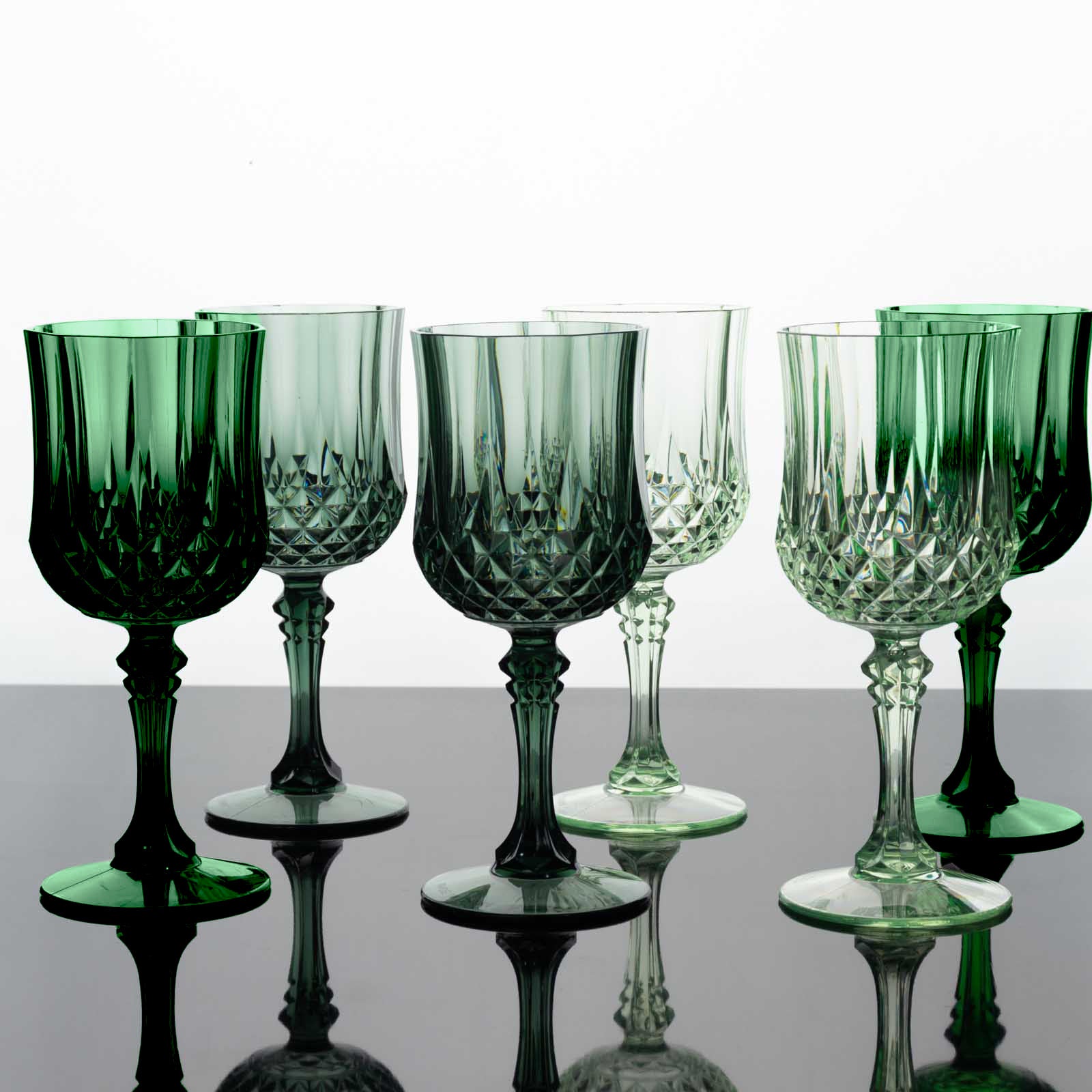 Assorted green crystal cut reusable plastic cocktail goblets.