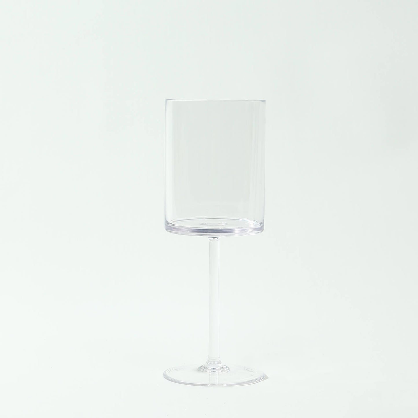 Clear plastic reusable cocktail glass with long stem, shatterproof design.