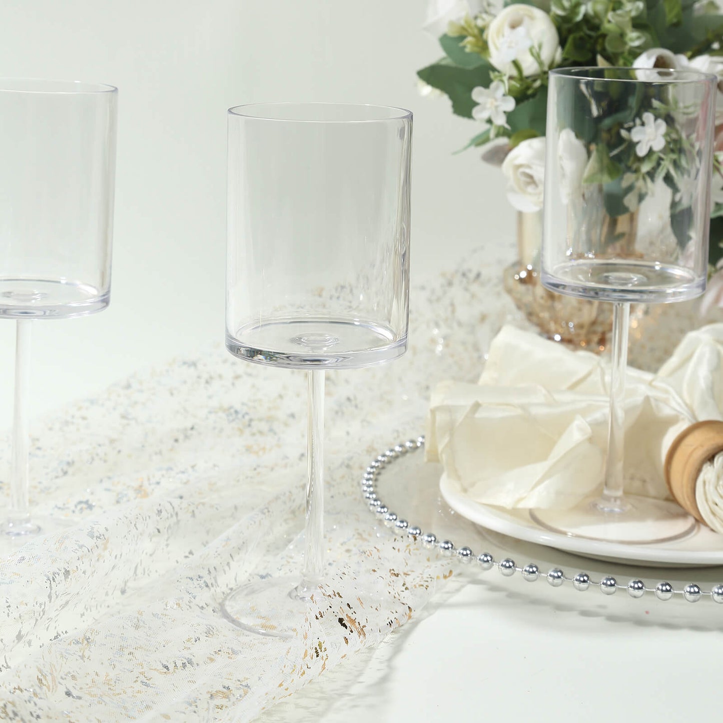 Clear plastic reusable cocktail glasses on a festive table setting.
