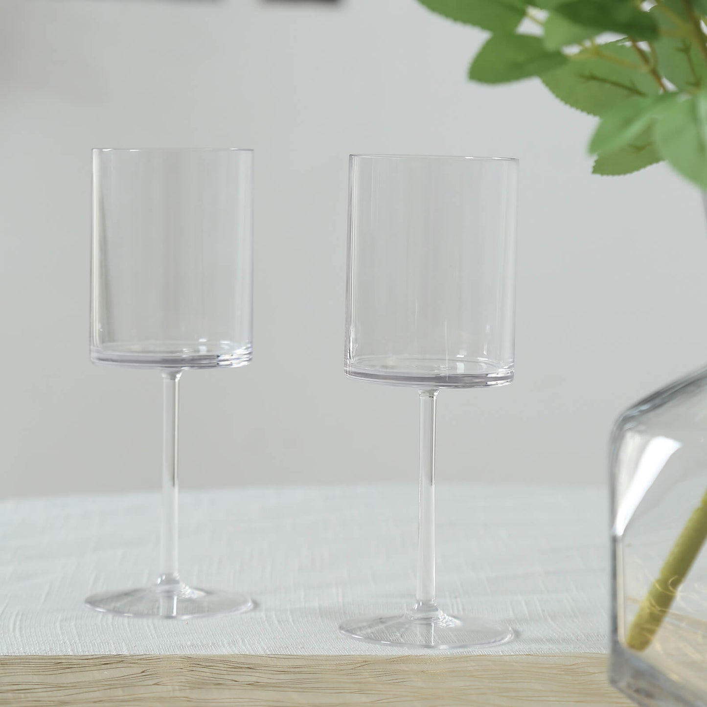 Clear plastic reusable cocktail glasses with long stem, shatterproof design.