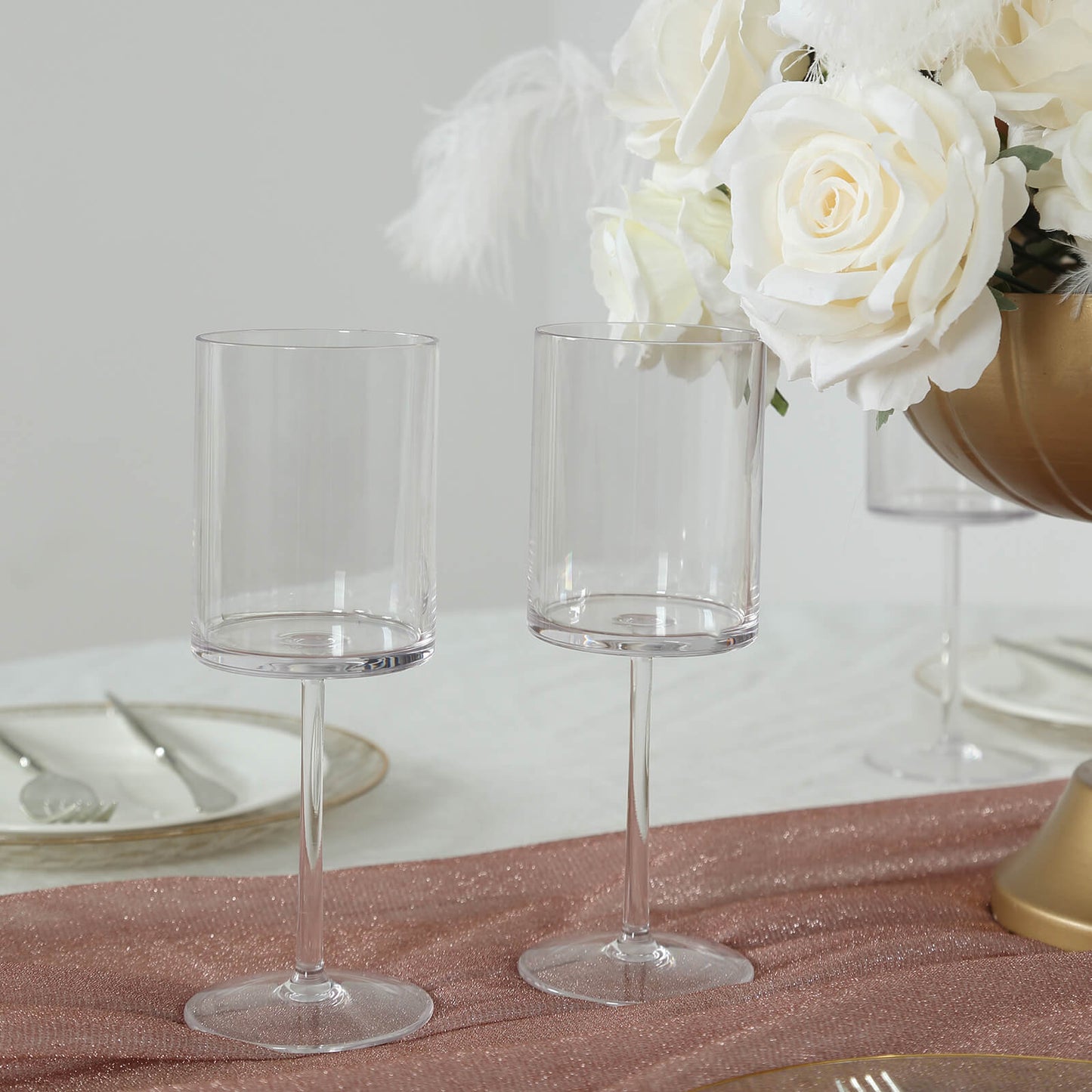 Clear plastic reusable cocktail glasses on a table setting.