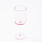 Transparent blush plastic reusable cocktail glass with long stem.