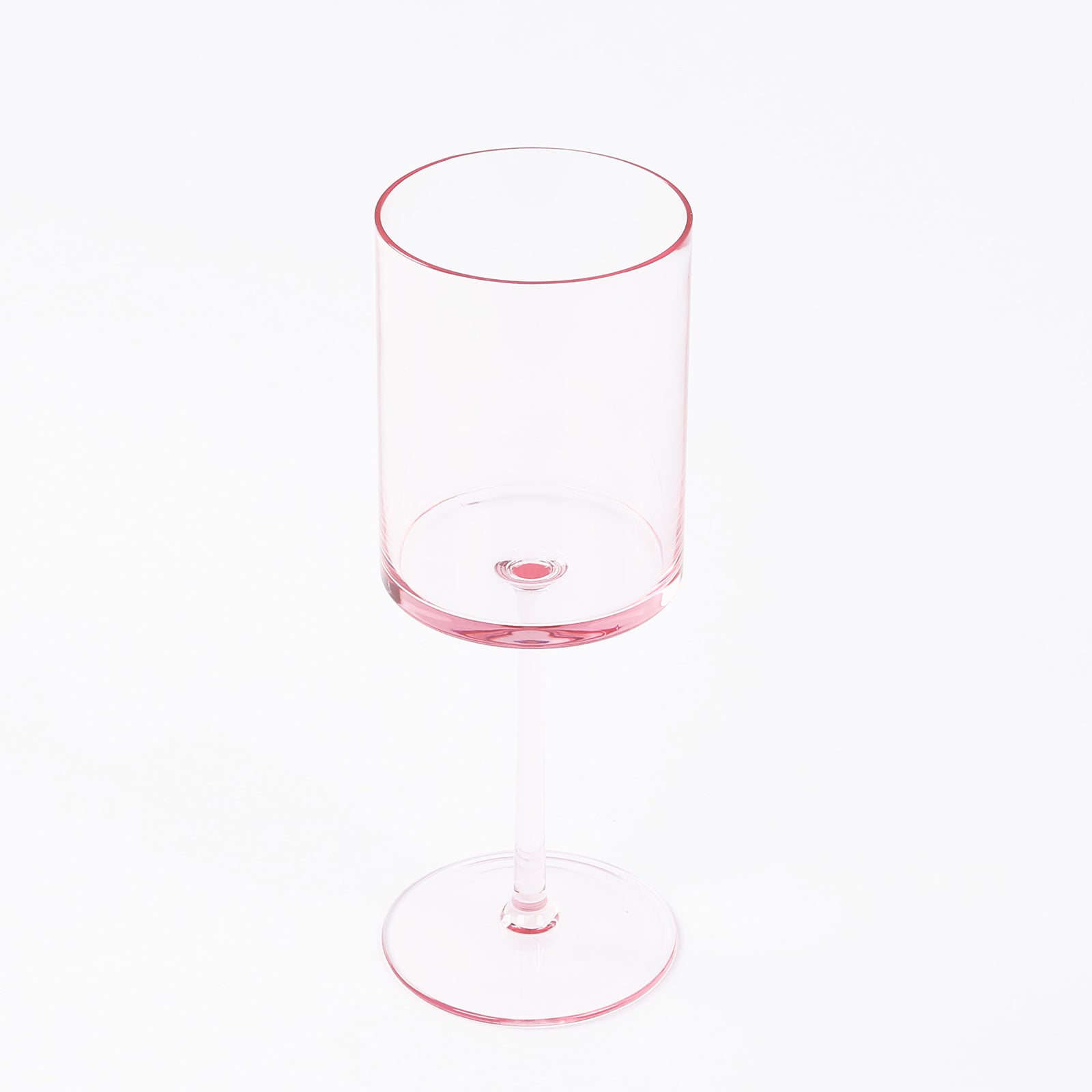 Transparent blush plastic reusable cocktail glass with long stem.