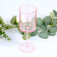 Transparent blush reusable cocktail glass with long stem.