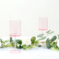 Transparent blush cocktail glasses with long stems.