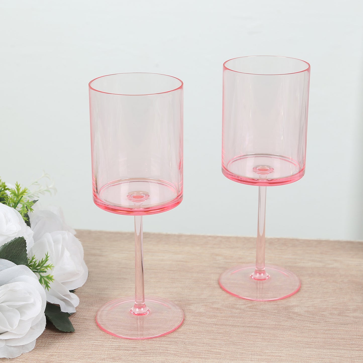Transparent blush cocktail glasses with long stems, shatterproof design.