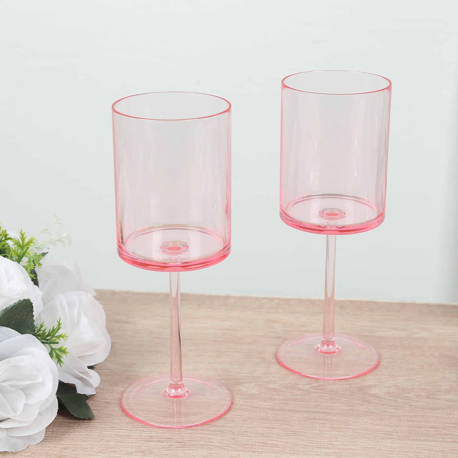 Transparent blush cocktail glasses with long stems, shatterproof design.