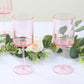 Transparent pink reusable cocktail glasses with long stems.