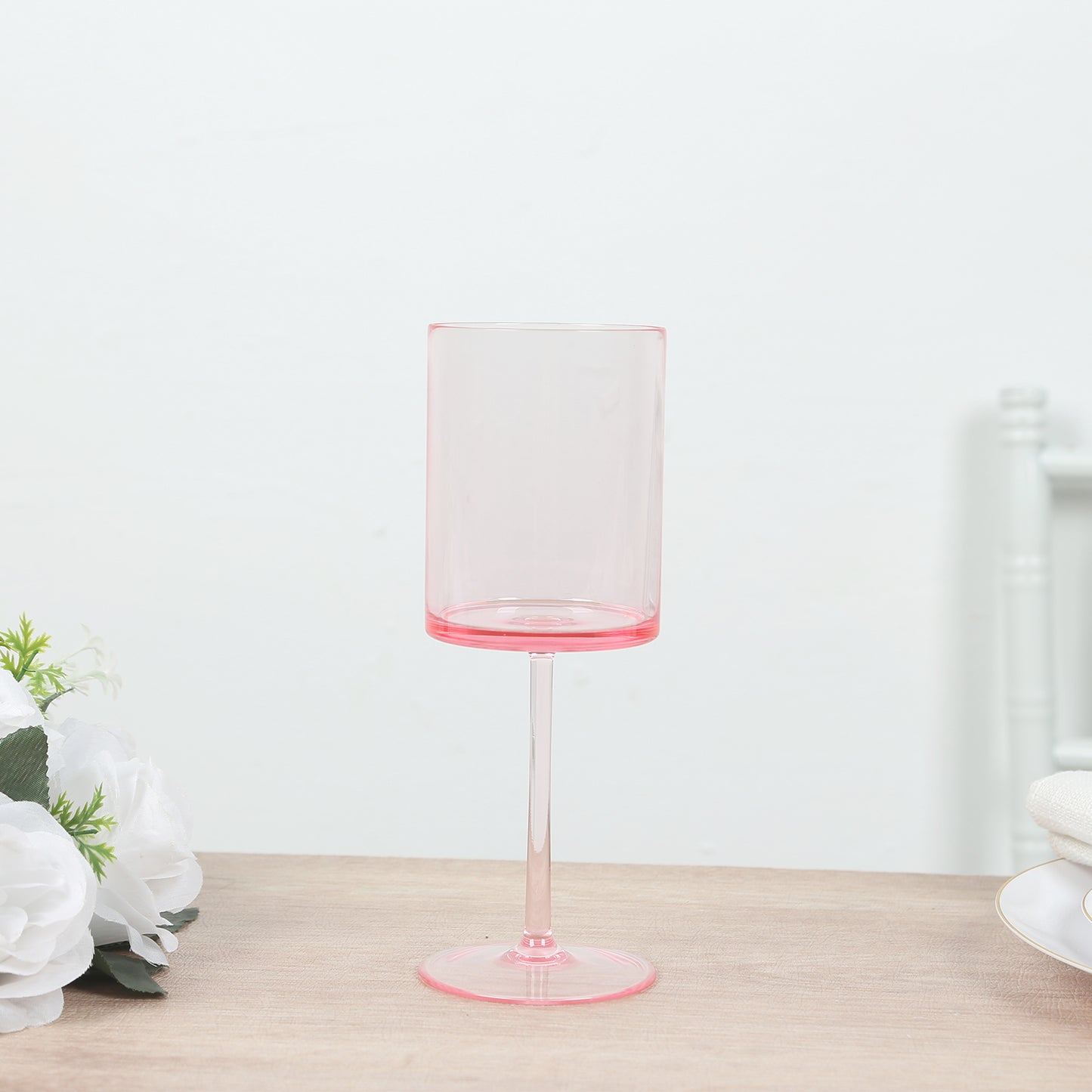 Pink transparent reusable cocktail glass with long stem.