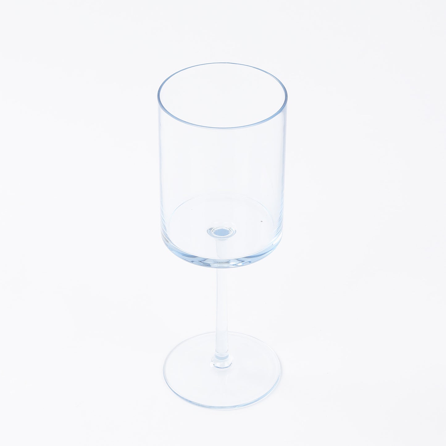 Transparent dusty blue reusable cocktail glass with long stem.