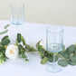 Transparent dusty blue reusable cocktail glasses with long stems.