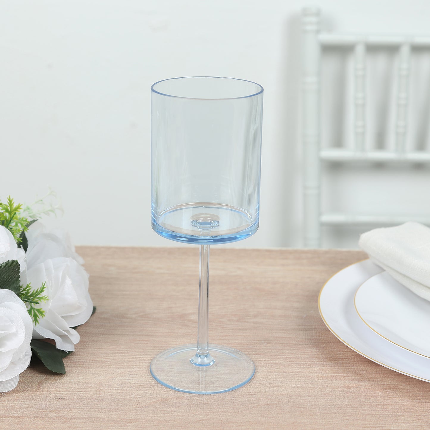 Transparent dusty blue shatterproof cocktail glass on a table.