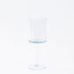Transparent dusty blue reusable cocktail glass with long stem.