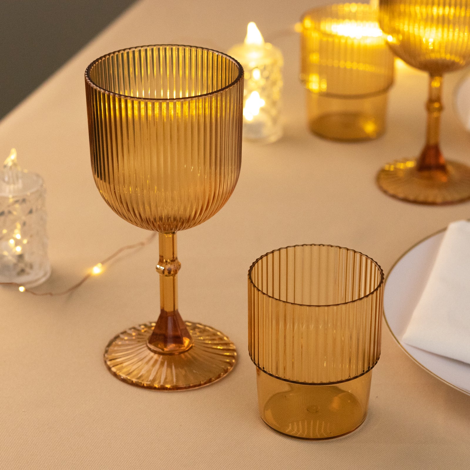 Amber gold ribbed reusable plastic wine goblets on a table.