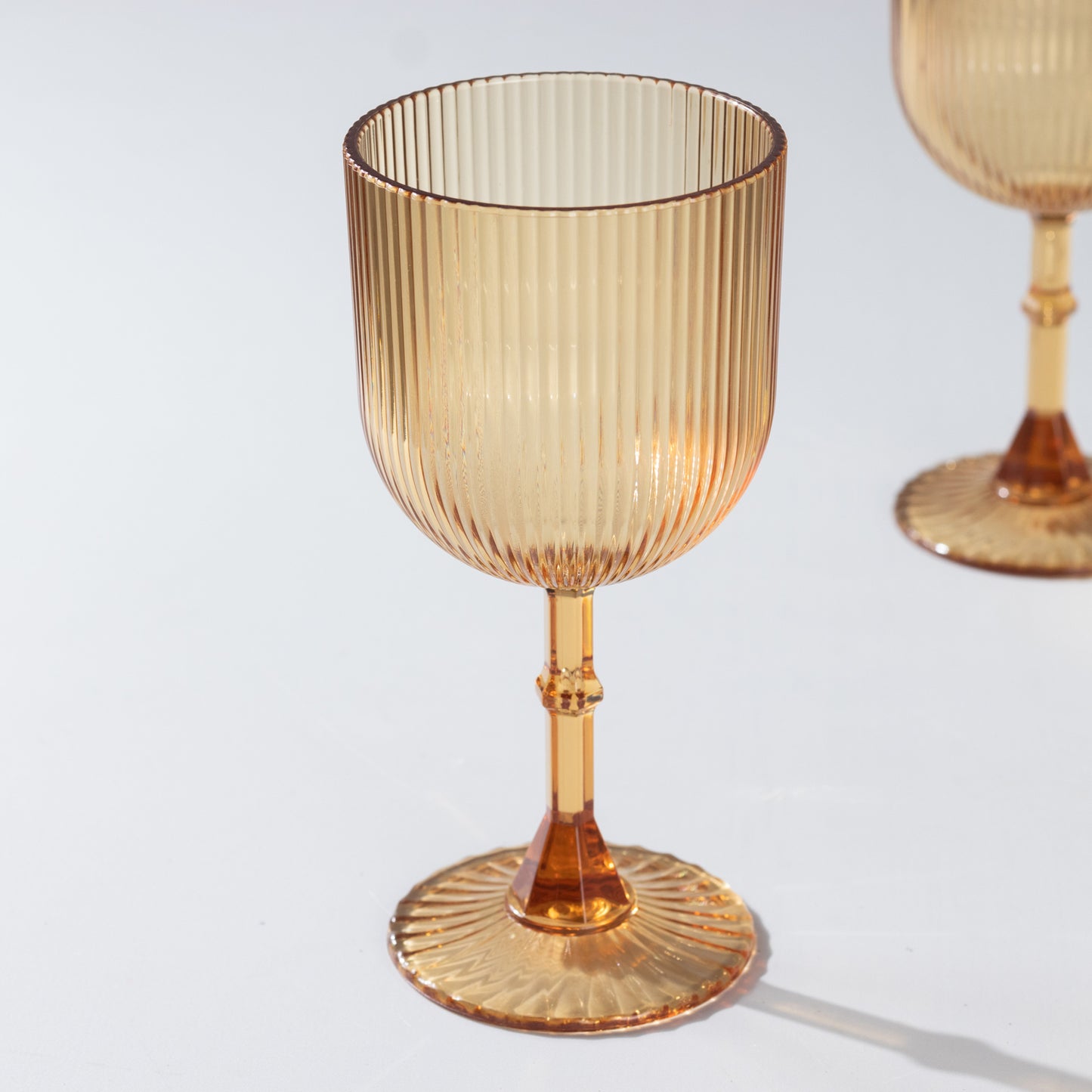 Amber gold ribbed reusable plastic wine goblet, shatterproof vintage design.