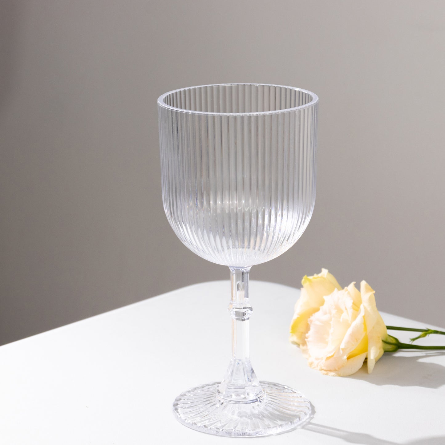 Clear ribbed reusable plastic wine goblet with vintage design.