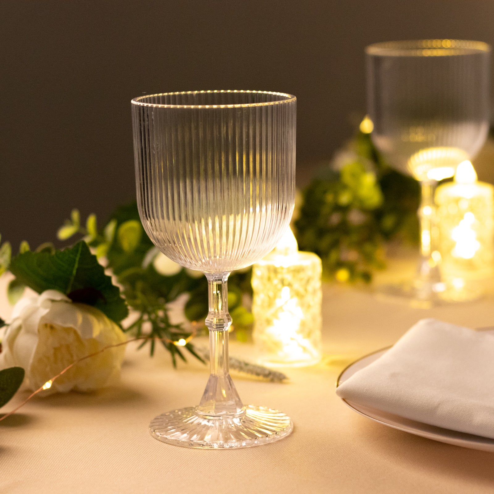 Clear ribbed shatterproof wine goblet on a table setting.