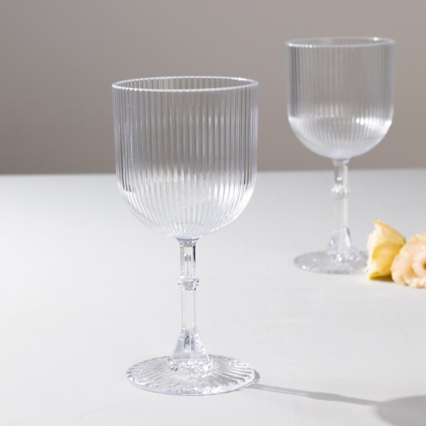 Clear ribbed reusable plastic wine goblets, shatterproof vintage design.
