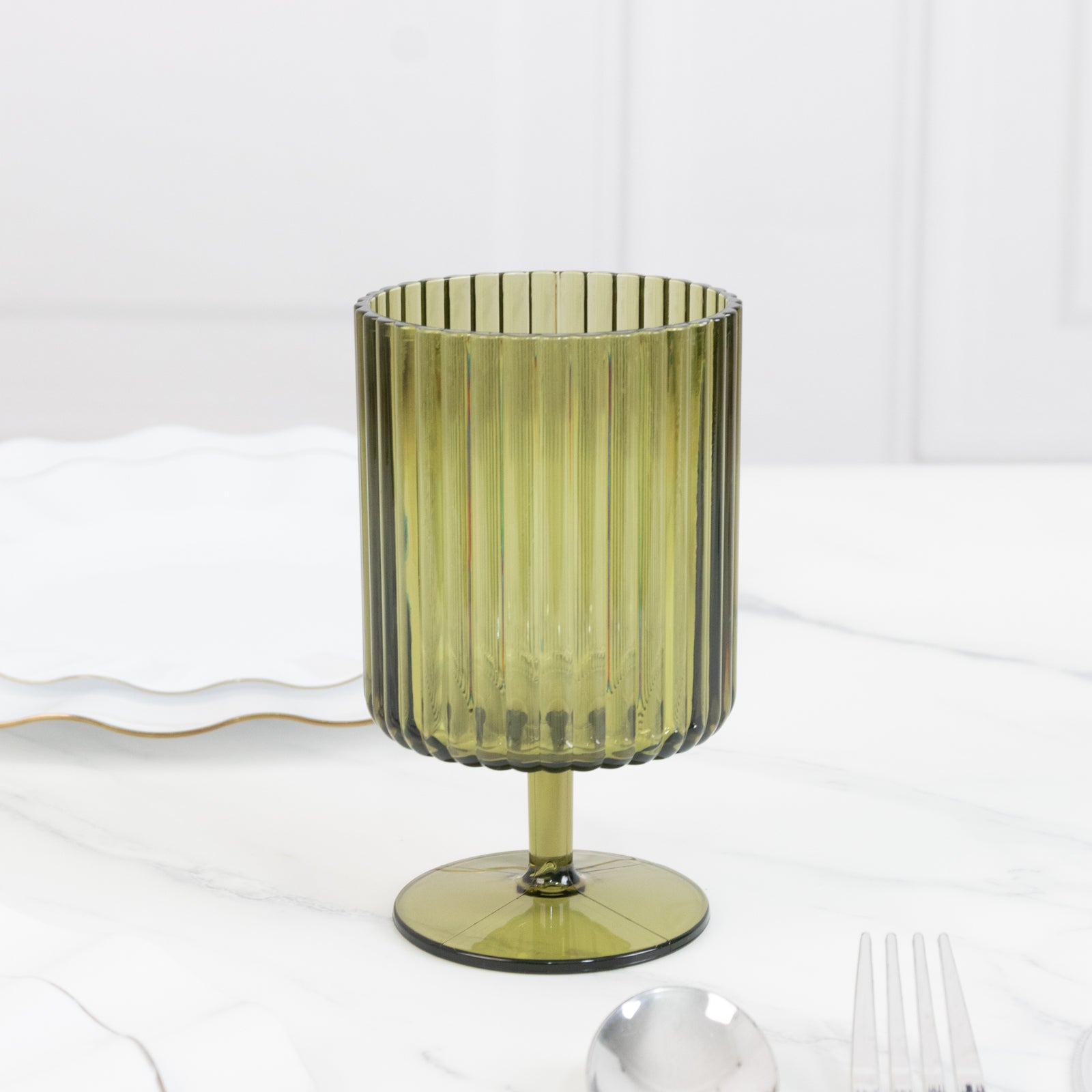 Dusty sage green ribbed plastic goblet on a marble table