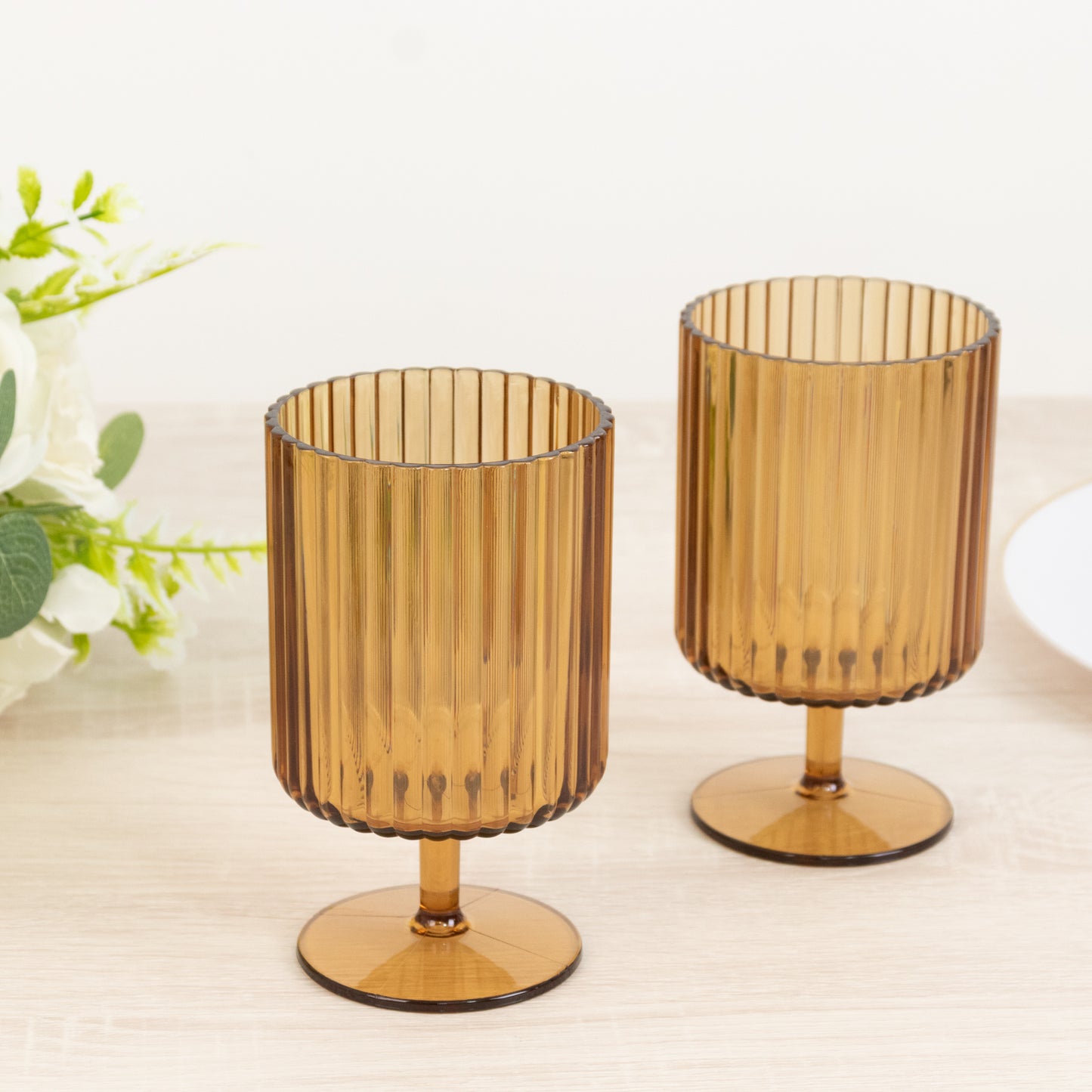 Amber gold vintage ribbed plastic goblets on a table.