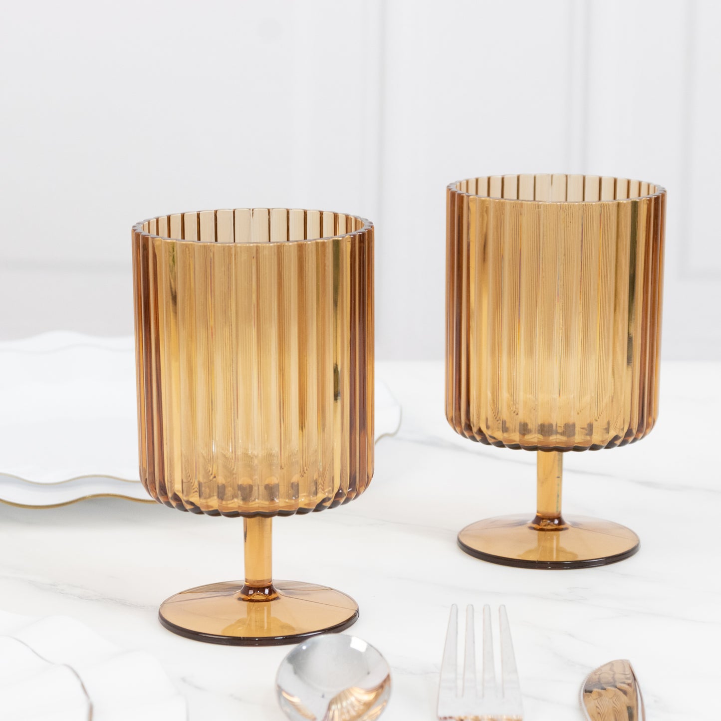 Amber gold vintage ribbed plastic goblets on a table.