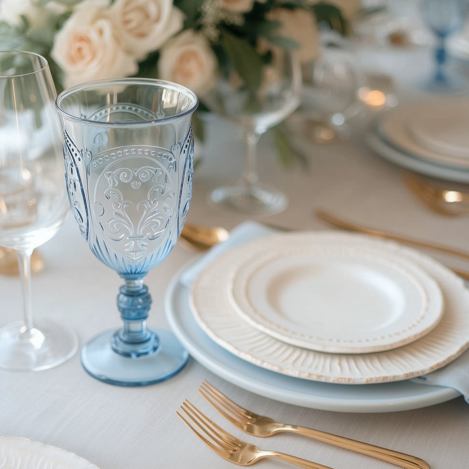 Transparent dusty blue vintage goblet on an elegant dining table setting.
