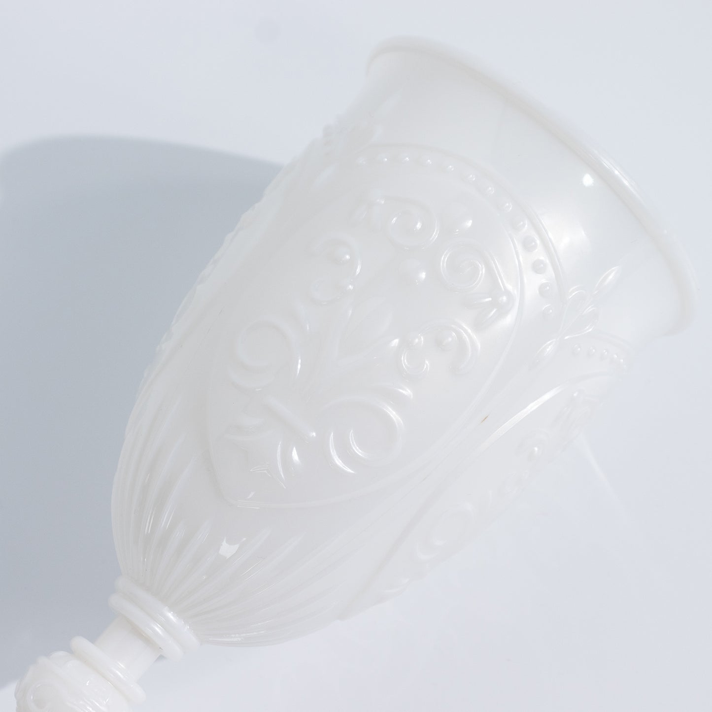 Pearl white vintage wine glass with embossed design, elegant drinkware.
