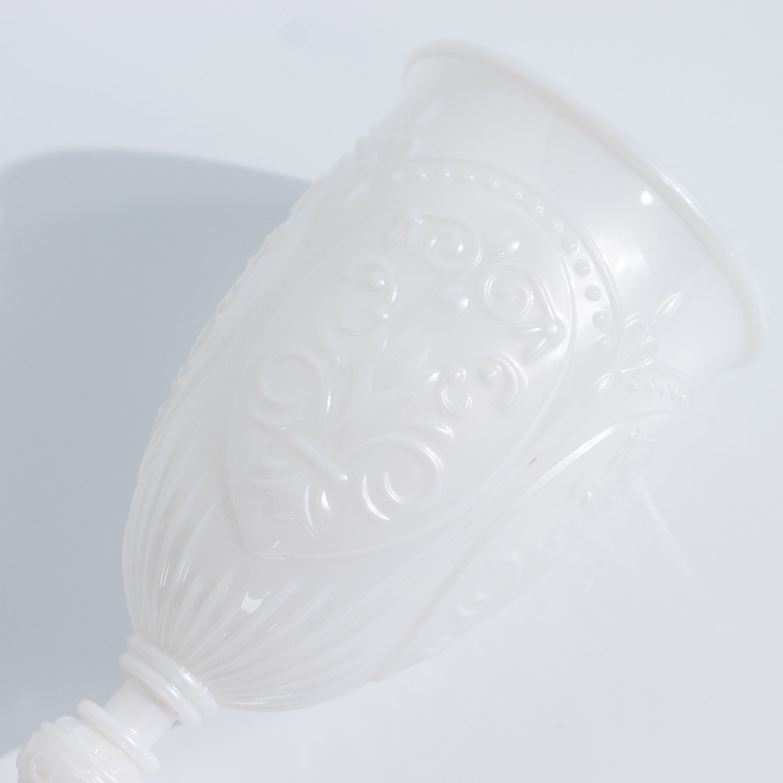 Pearl white vintage wine glass with embossed design, elegant drinkware.