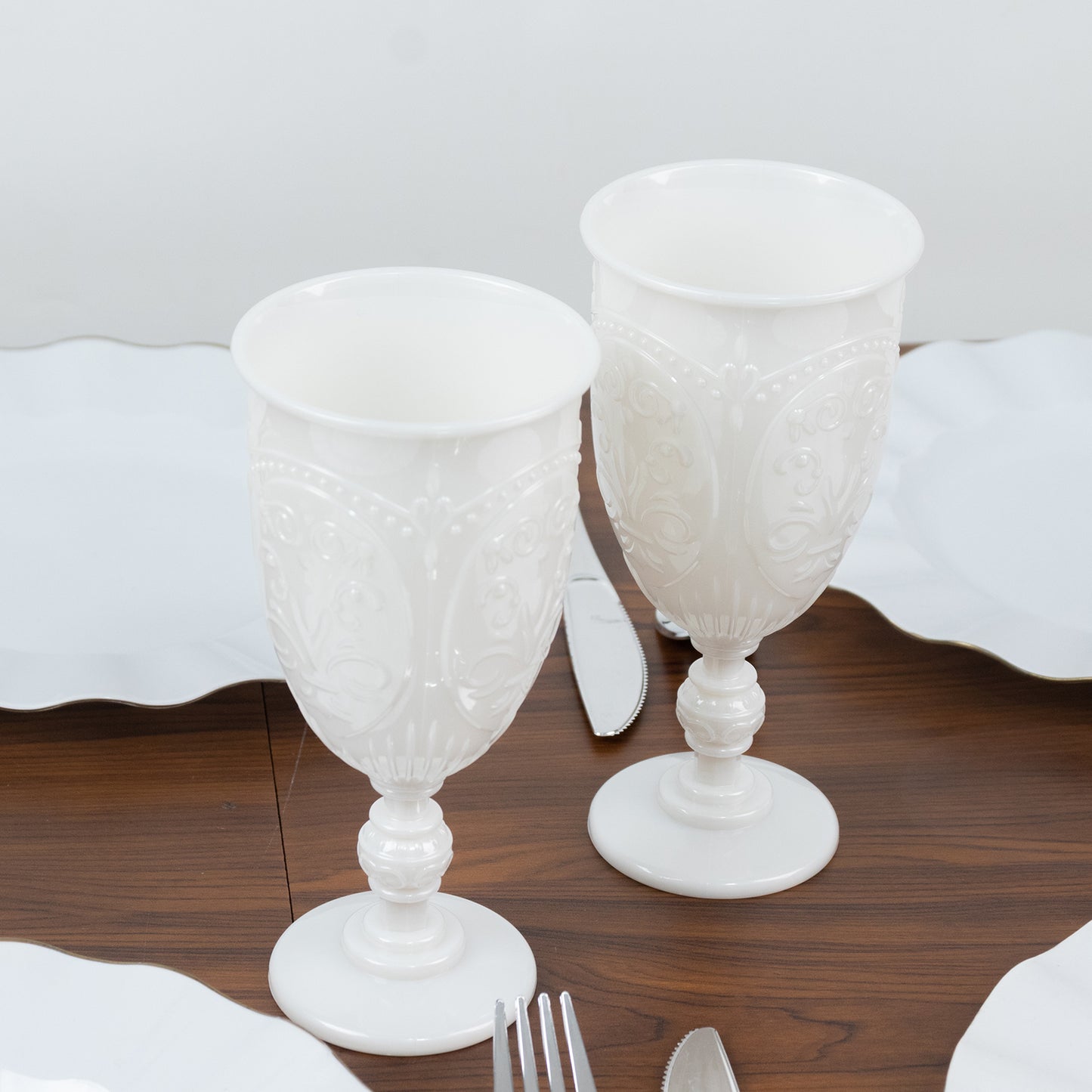 Pearl white vintage goblets with embossed design, elegant drinkware.
