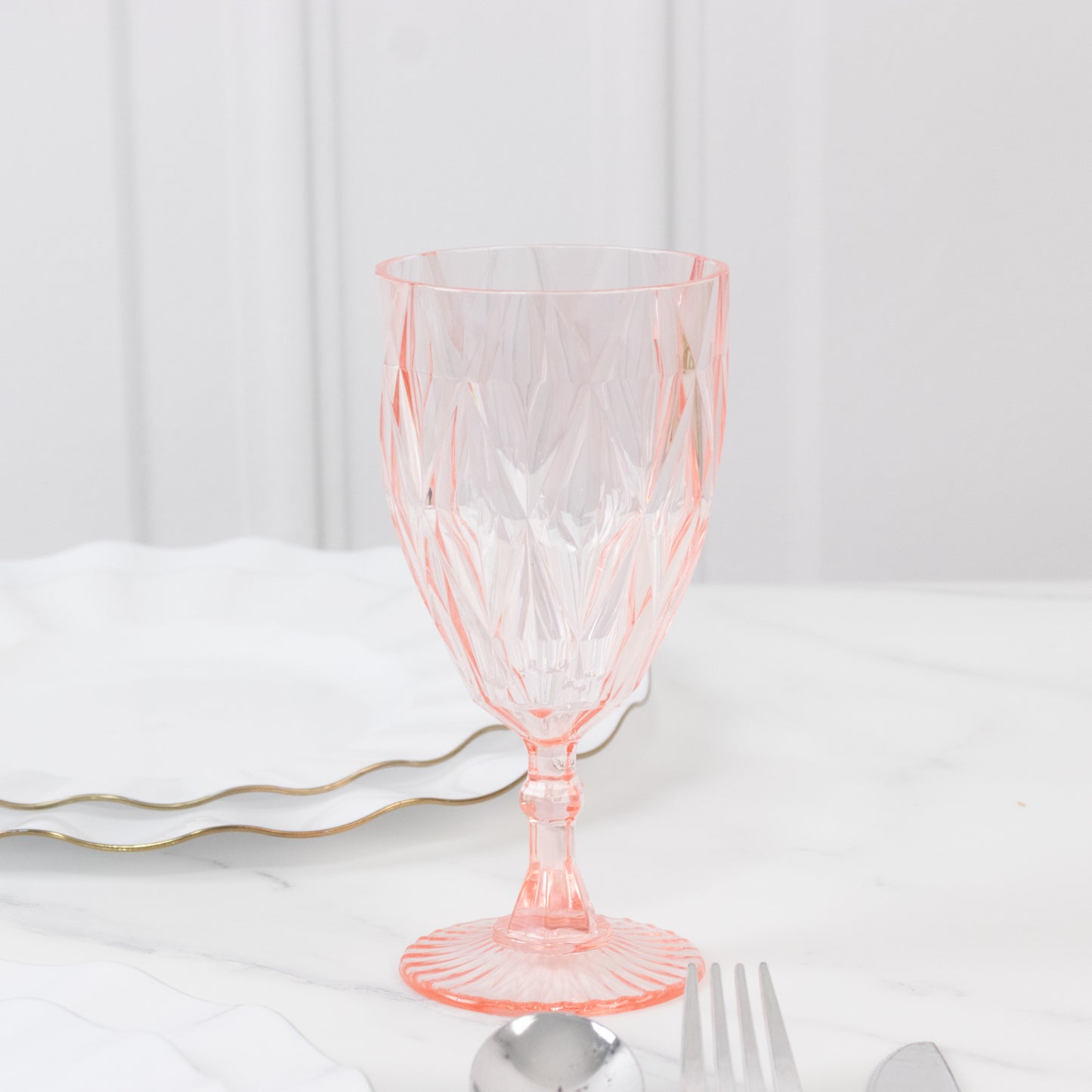 Blush vintage diamond cut plastic goblet on a marble table setting.