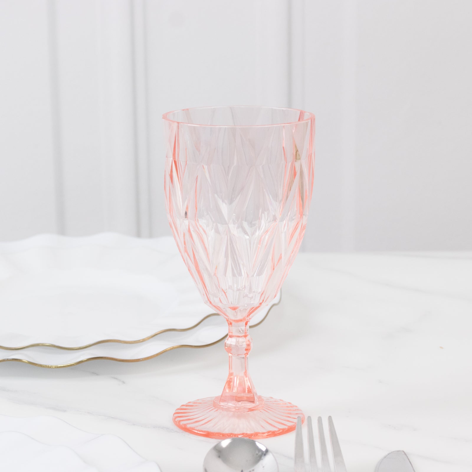 Blush vintage diamond cut plastic goblet on a marble table setting.