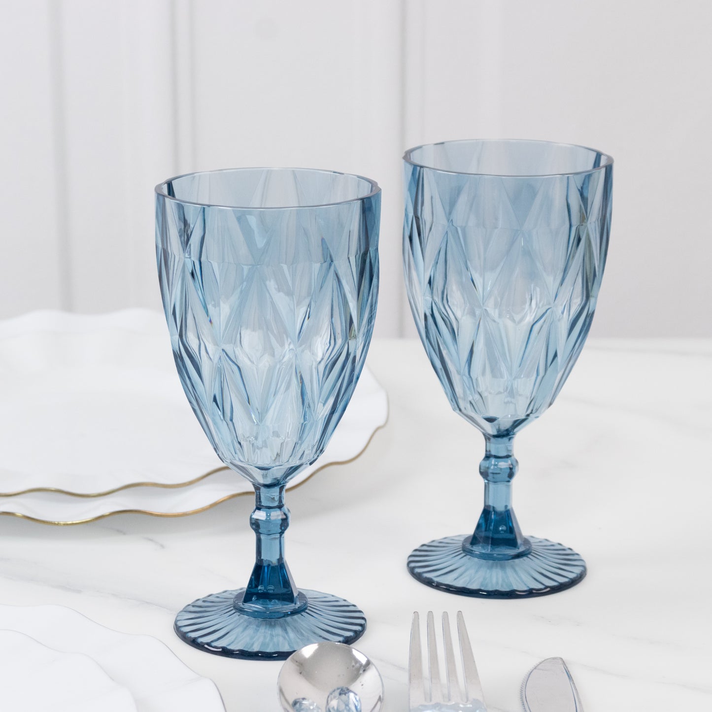 Dusty blue vintage diamond cut plastic goblets on a table setting.