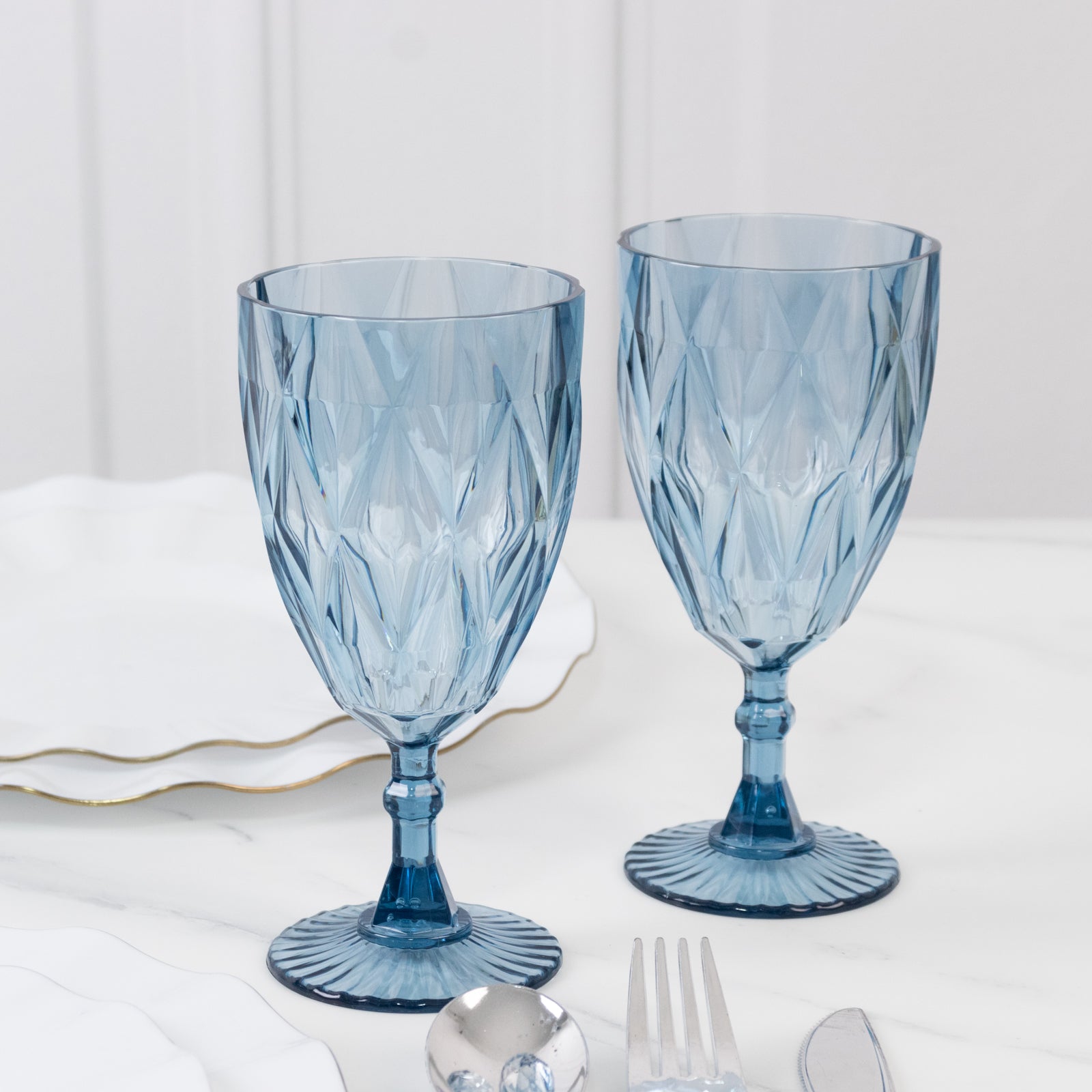 Dusty blue vintage diamond cut plastic goblets on a table setting.