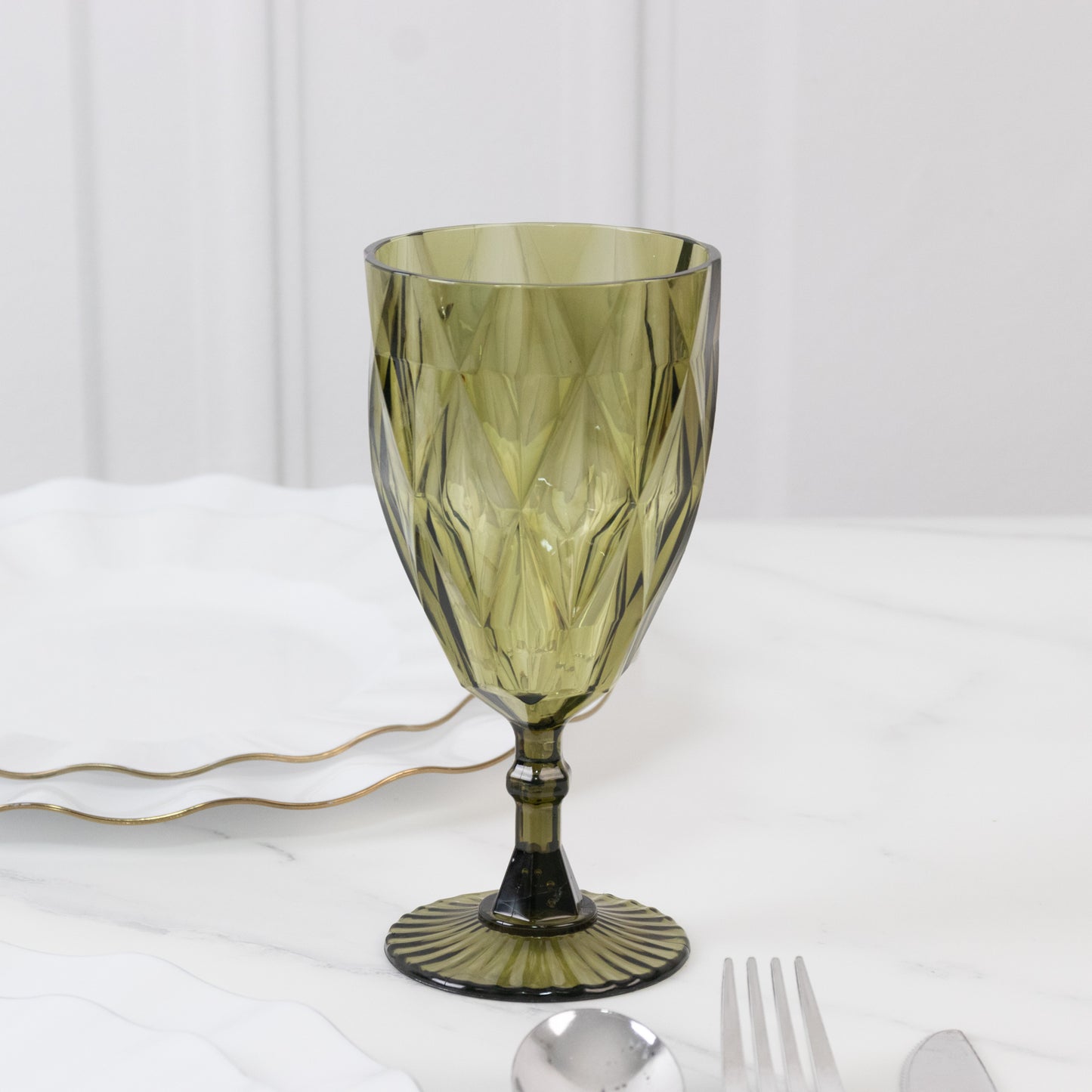Dusty sage green vintage diamond cut plastic goblet on a table setting.