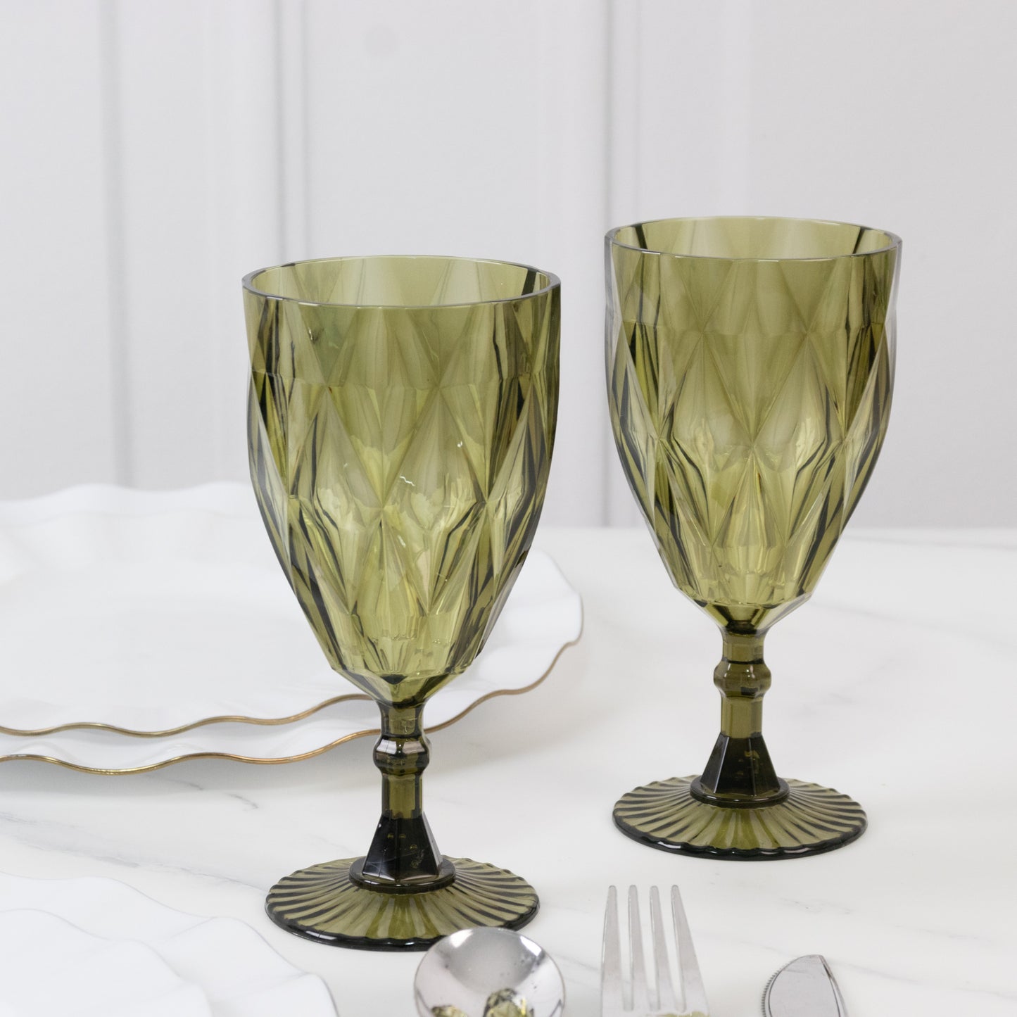 Dusty sage green vintage diamond cut plastic goblets on a table.