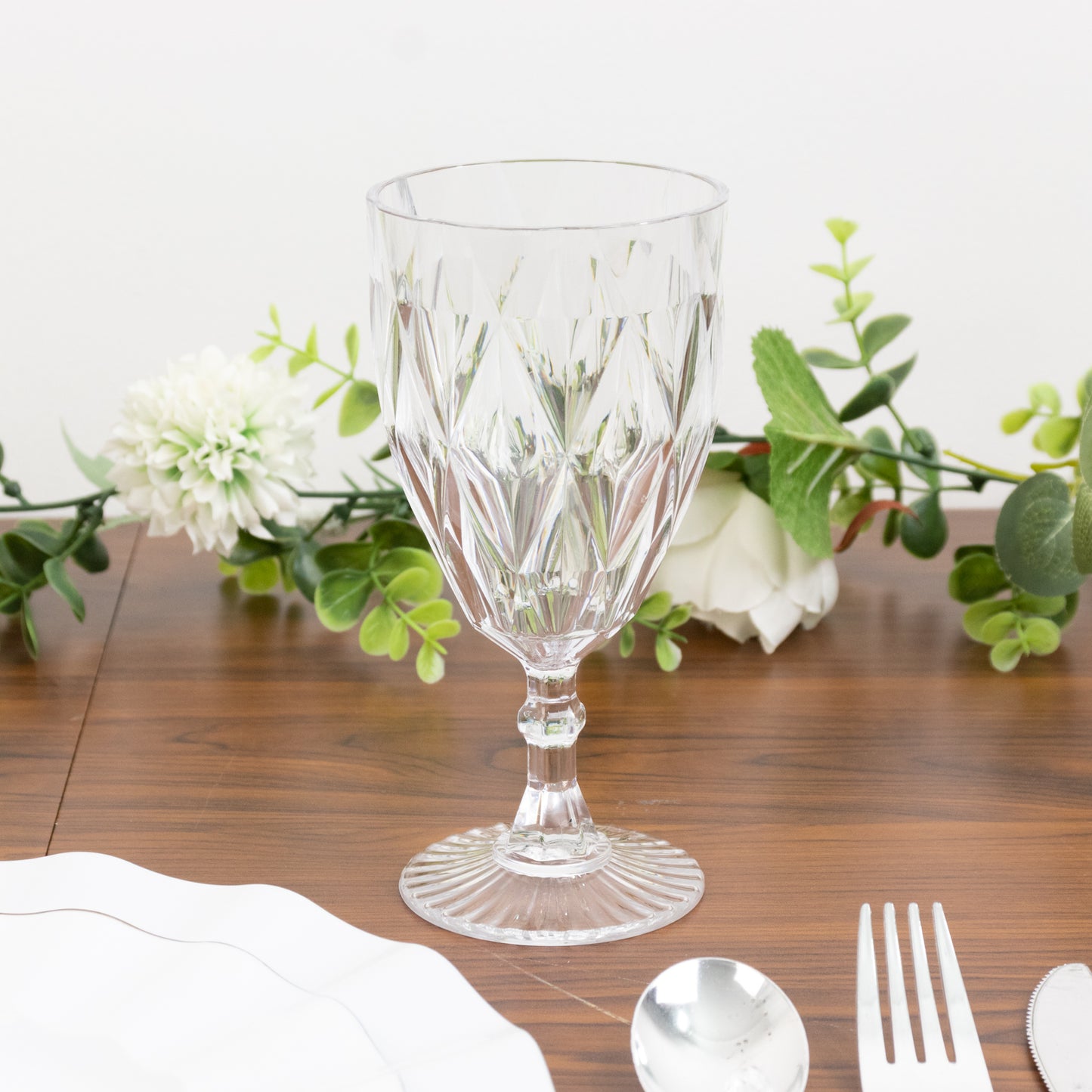 Clear vintage diamond cut plastic goblets on a table setting.