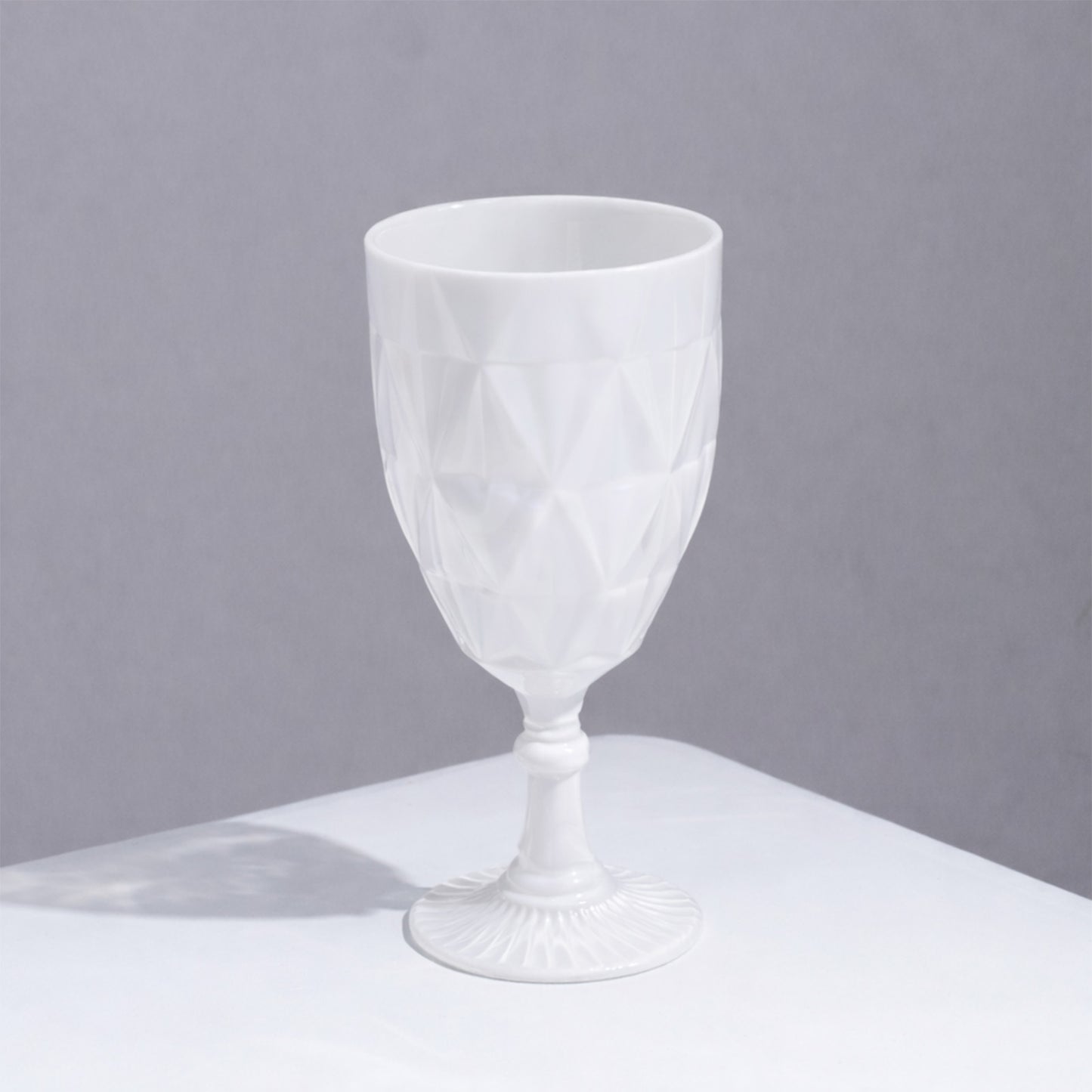 Pearl White Vintage Diamond Cut Plastic Goblet on a white surface.
