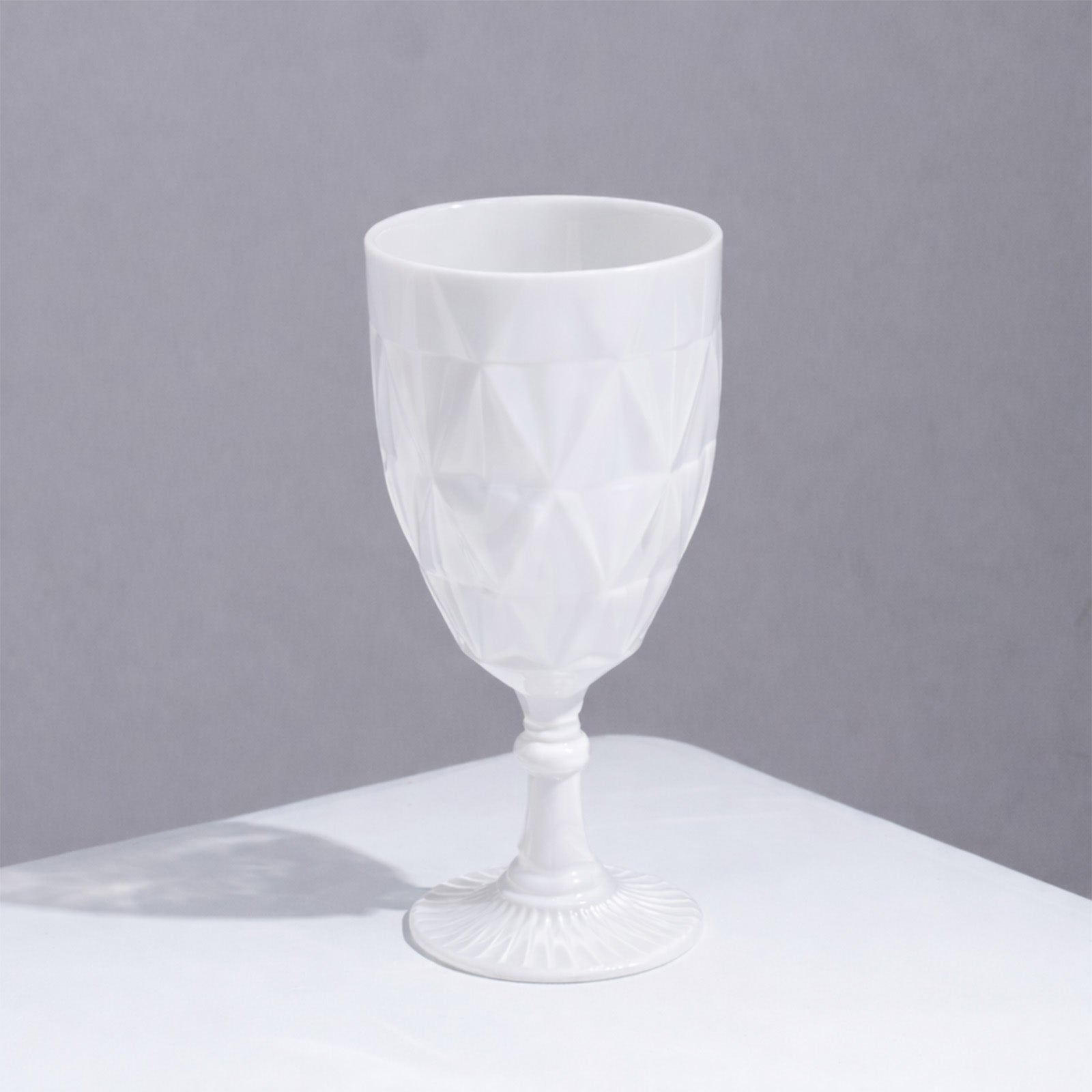 Pearl White Vintage Diamond Cut Plastic Goblet on a white surface.