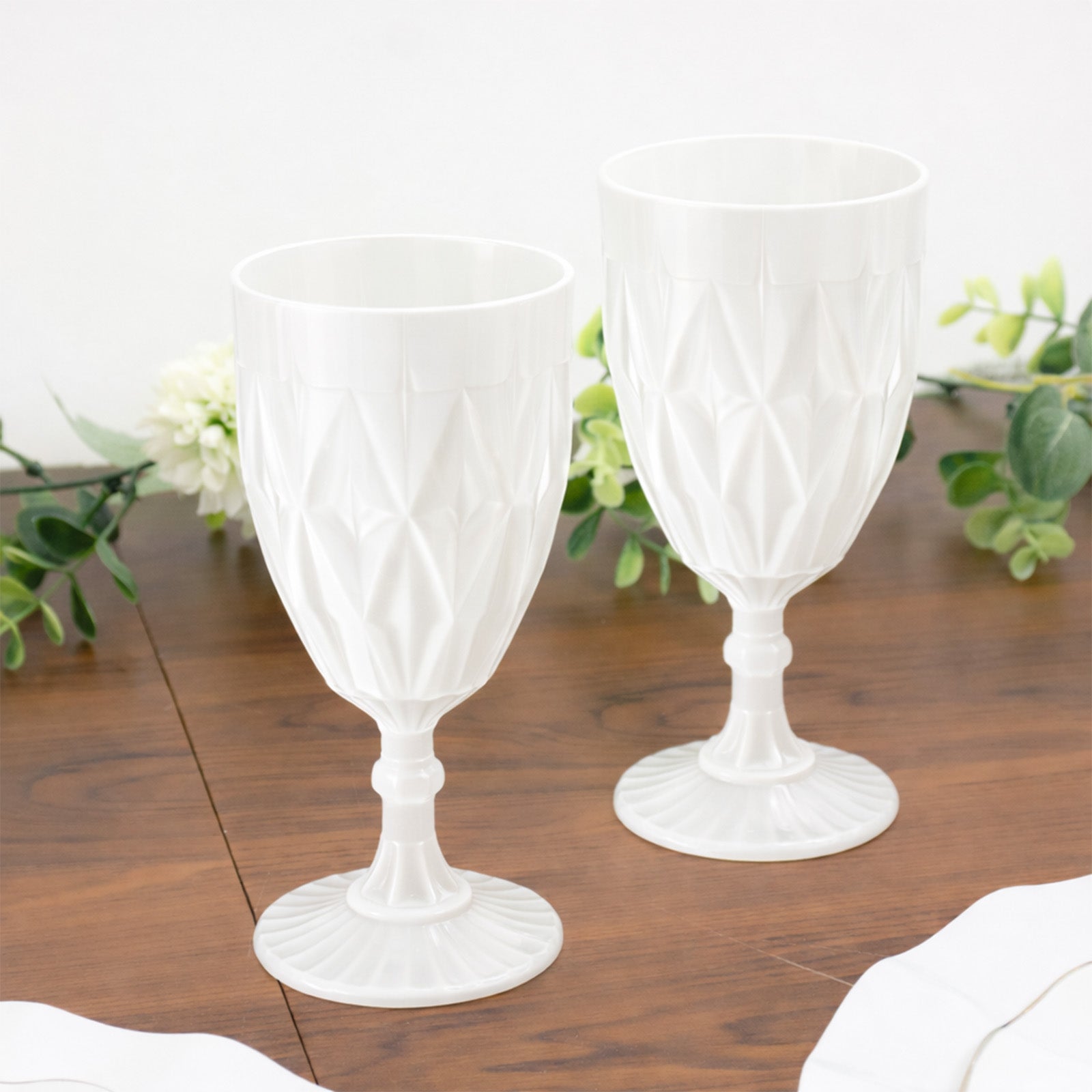Pearl white vintage diamond cut plastic goblets on a wooden table.