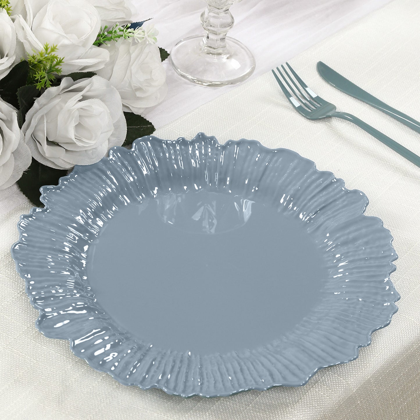 Dusty blue plastic dinner plate with elegant design on a table setting.