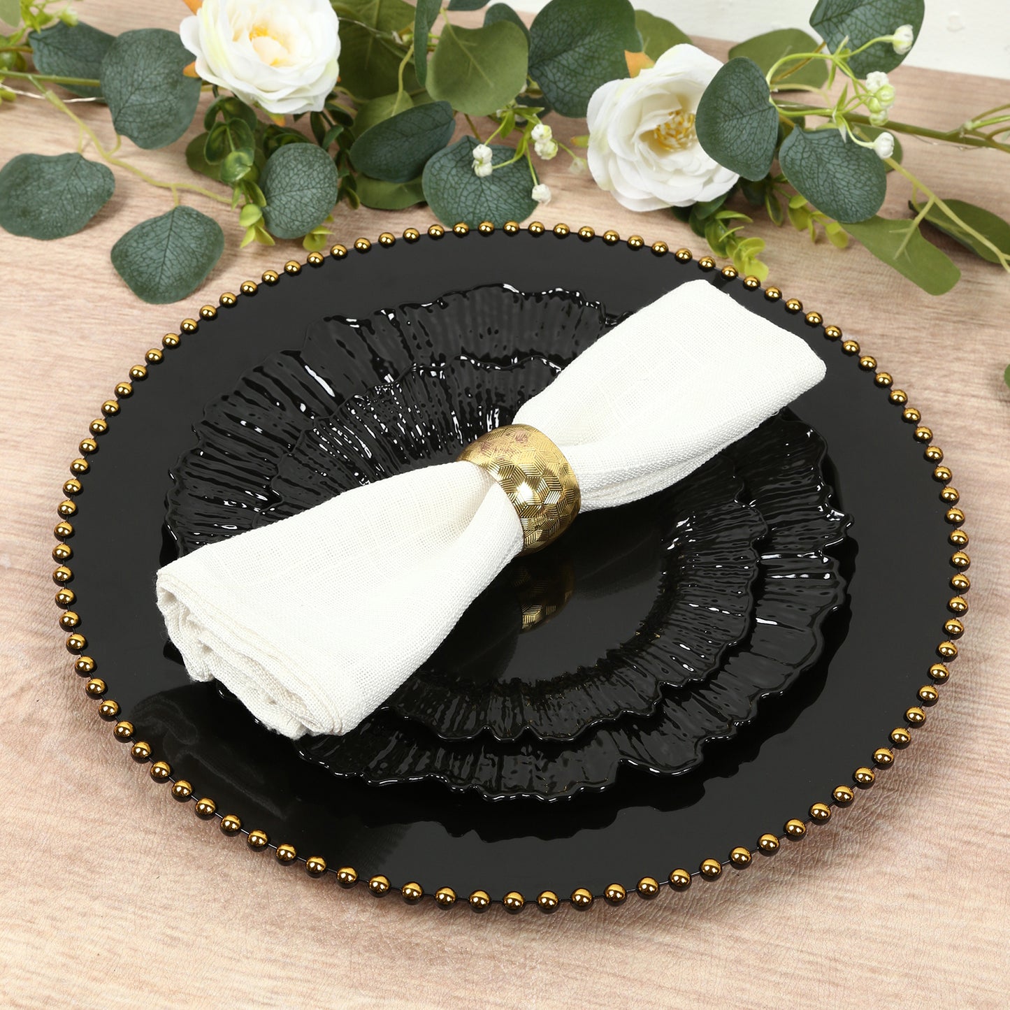 Black dinner plate with elegant reef design and a napkin.