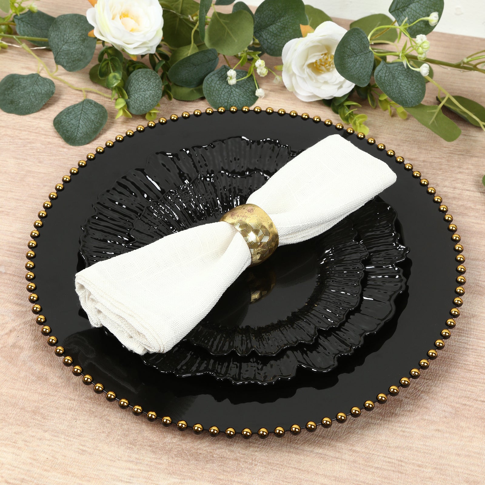 Black dinner plate with elegant reef design and a napkin.
