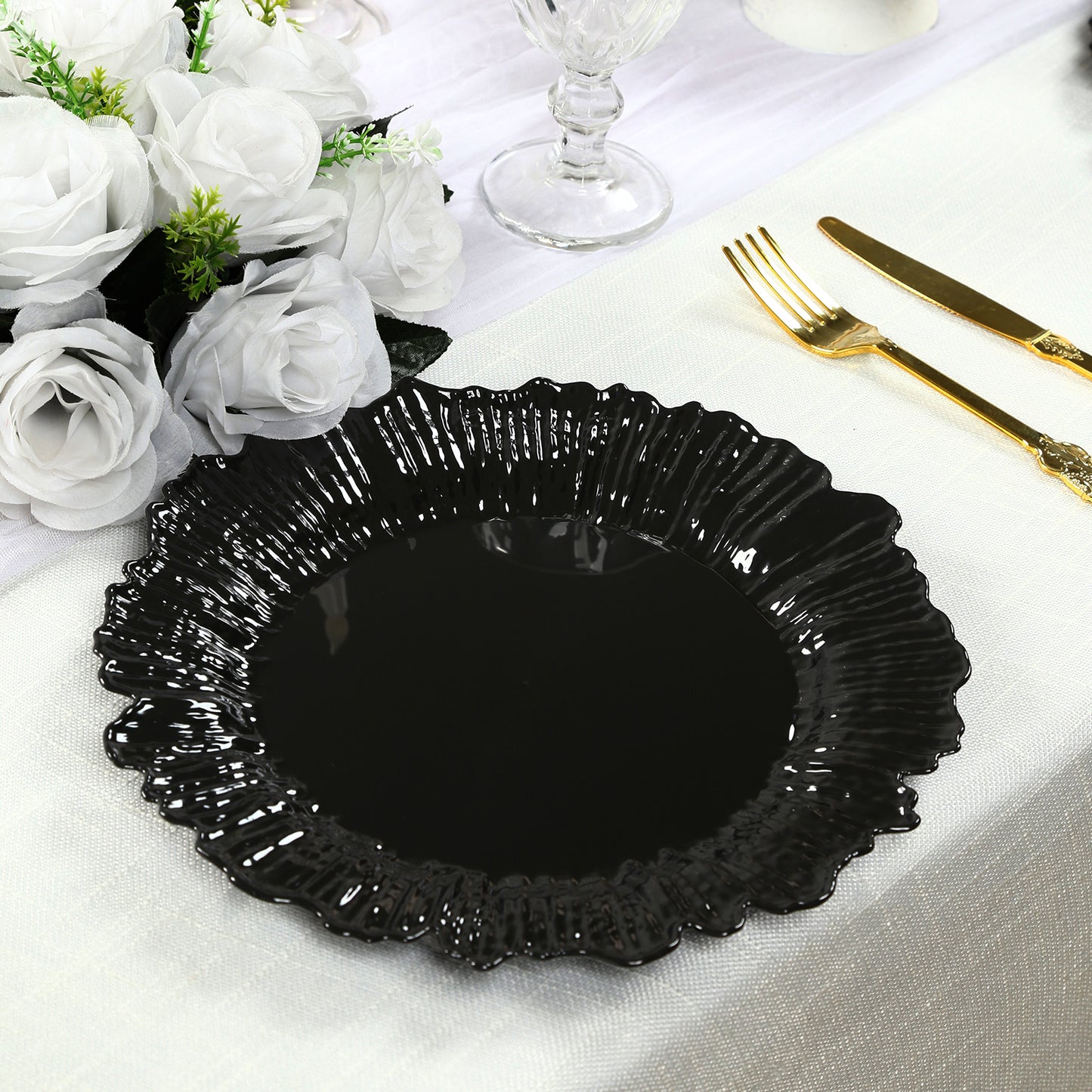 Black disposable dinner plate with elegant reef design on a table setting.