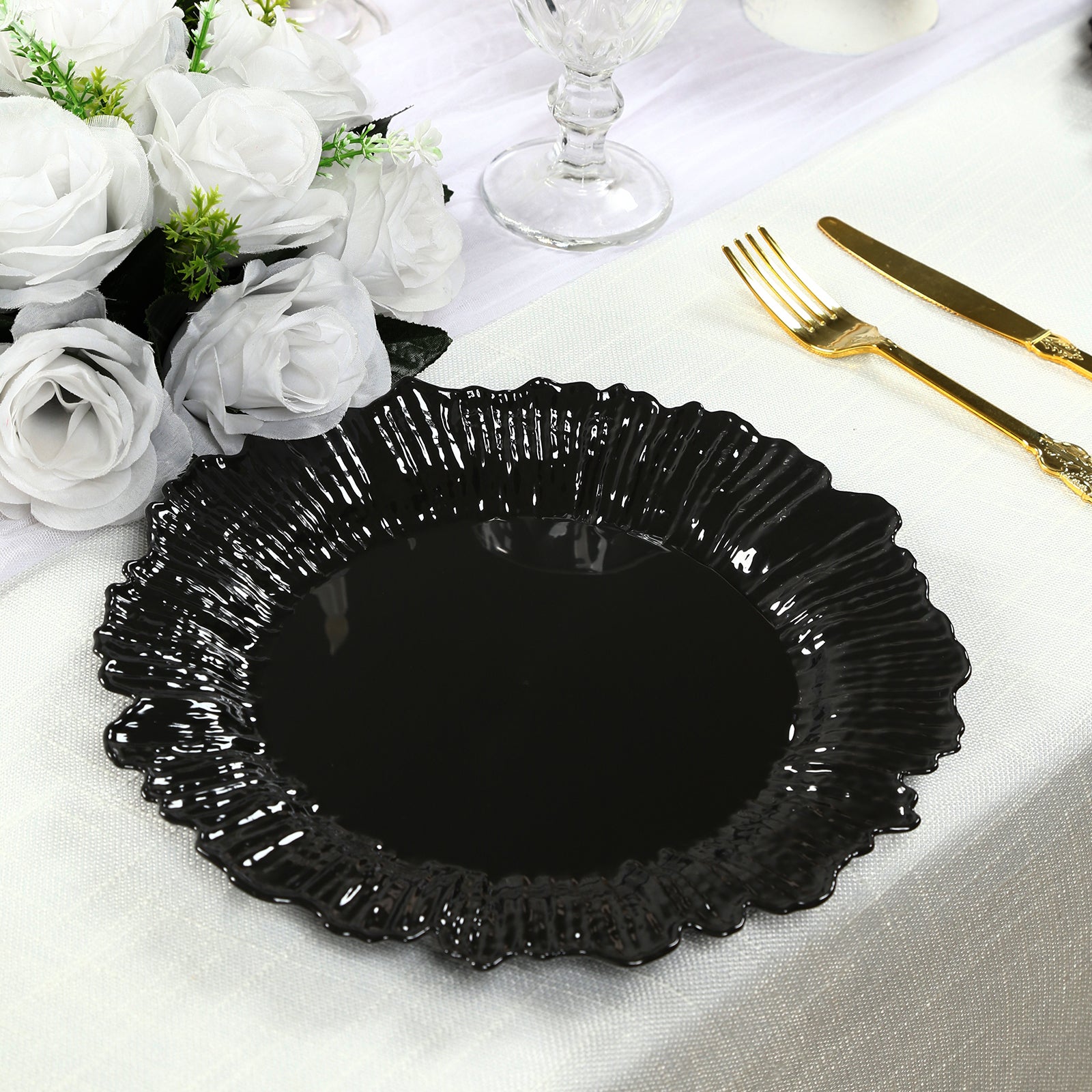 Black disposable dinner plate with elegant reef design on a table setting.