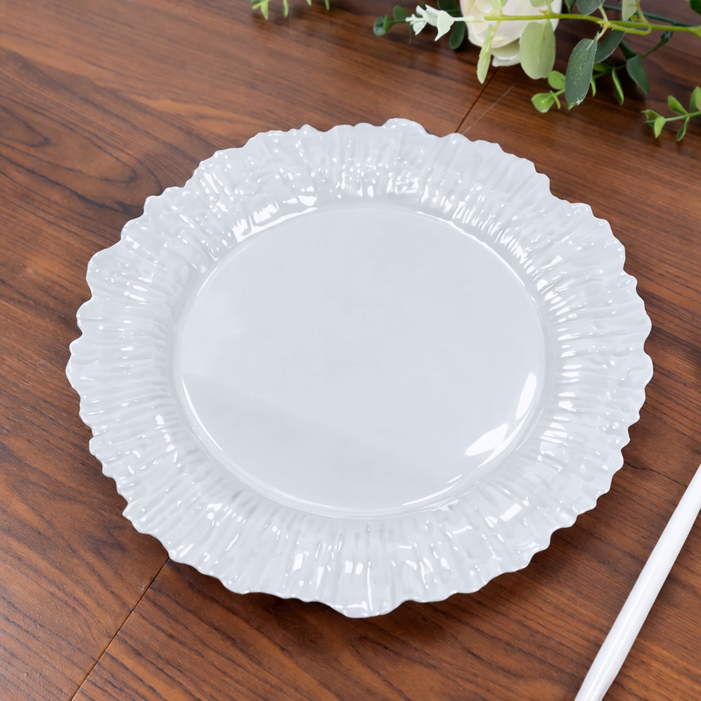 Pearl white disposable dinner plate with reef design on wooden table.