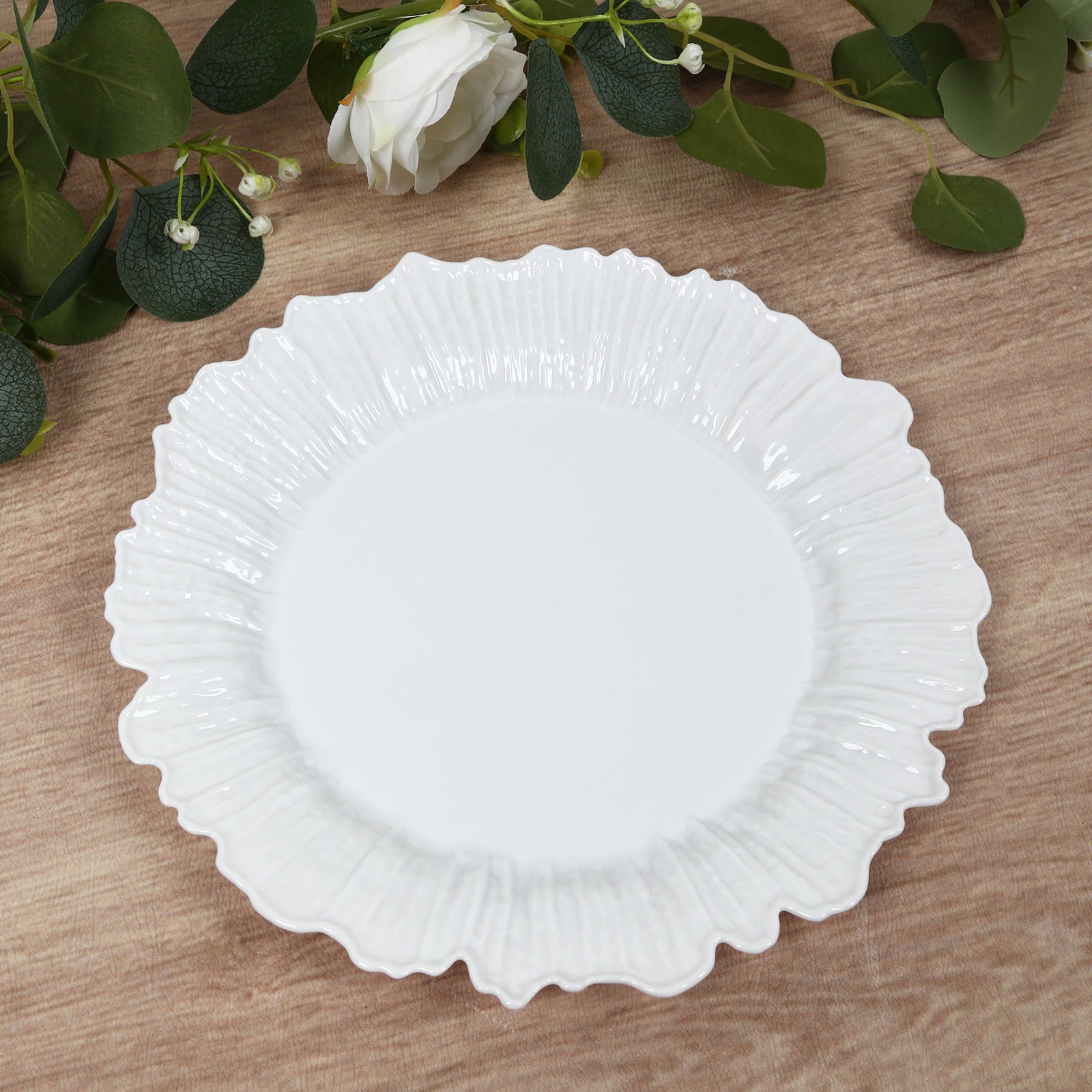 White dinner plate with reef design on a wooden surface.