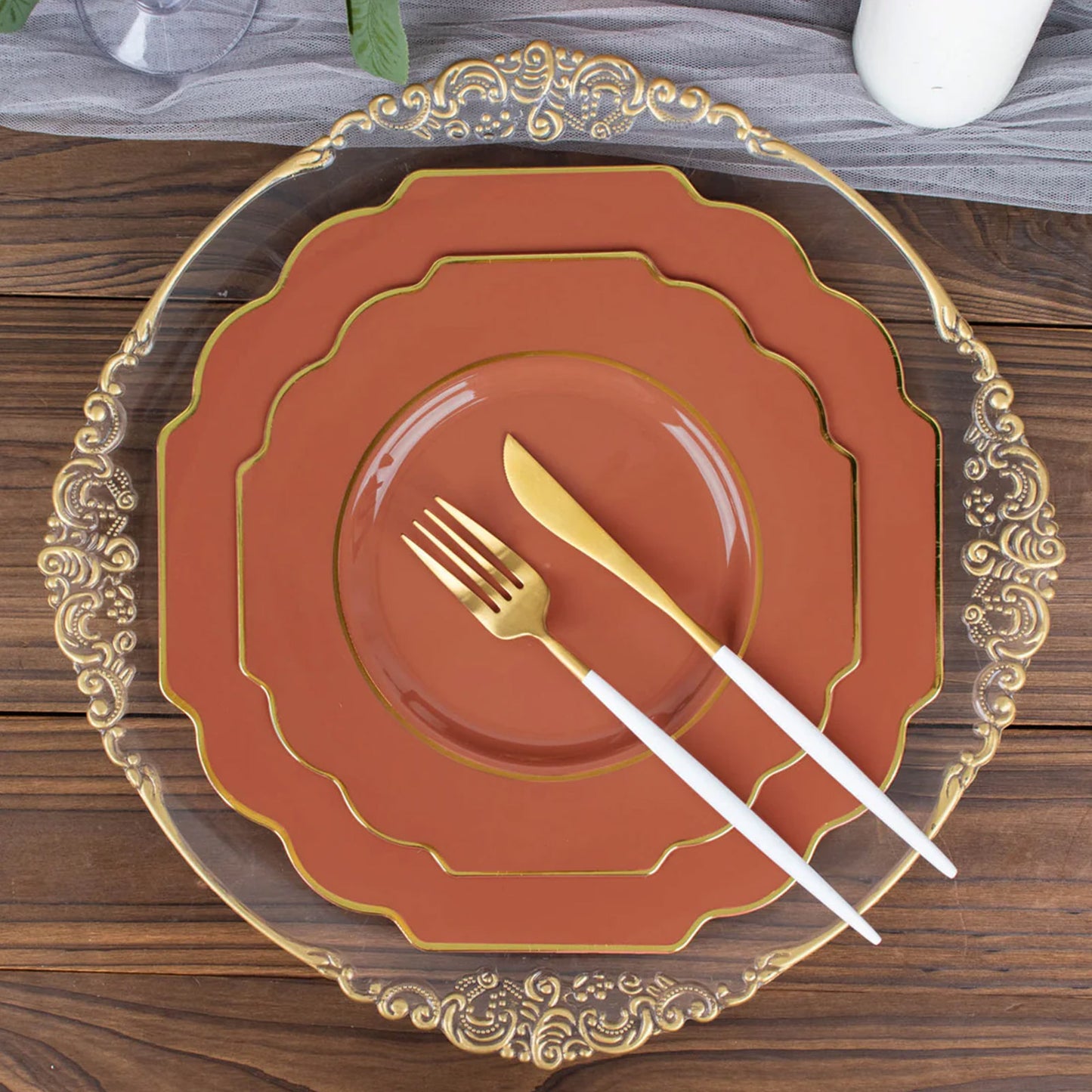 Rust terracotta dessert plates with gold rim on decorative platter.