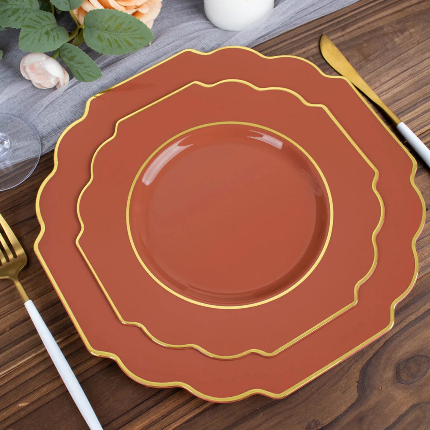 Rust terracotta dessert plates with gold rim on a wooden table.
